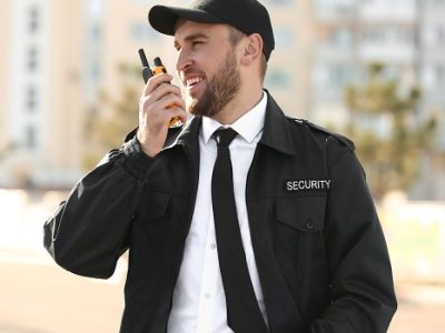 Male security guard with portable radio transmitter outdoors Male security guard with portable radio transmitter outdoors